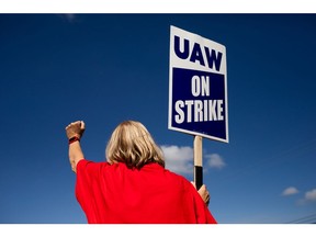 A UAW member pickets outside Ford's assembly plant. Photographer: Emily Elconin/Bloomberg