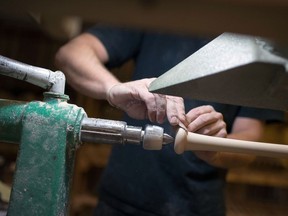 An employee performs the final sanding on a maple wood bat during production at a manufacturing facility in Ottawa. Growth in the Canadian economy was flat in July.
