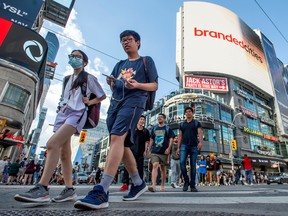 Pedestrians in downtown Toronto. Canada's population grew by 1.1 million people last year, Statistics Canada says.