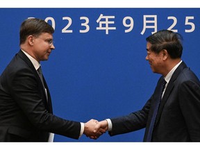 Valdis Dombrovskis with He Lifeng in Beijing on Sept. 25. Photographer: Pedro Pardo/AFP/Getty Images