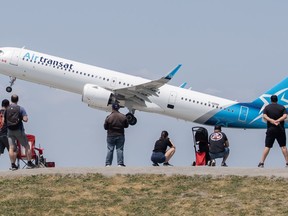 People look on as an Air Transat plane takes off at Trudeau in Montreal, Sunday, June 11, 2023. Transat AT Inc. reported a third-quarter profit of $57.3 million compared with a loss of $106.5 million in the same quarter last year.