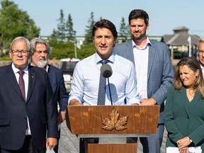 Canadian Housing Minister Sean Fraser stands behind Prime Minister Justin Trudeau during a news conference in Prince Edward Island in August.