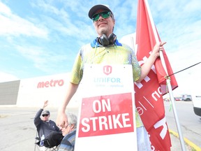 Striking Metro grocery store workers hold picket lines in Toronto in August.