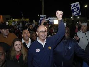 United Auto Workers President Shawn Fain walks with union members striking at Ford's Michigan Assembly Plant in Wayne, Mich., early Friday, Sept. 15, 2023.