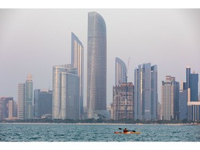 An Emirati woman paddles a canoe past skyscrapers in Abu Dhabi, United Arab Emirates, on Wednesday, Oct. 2, 2019.  Photographer: Christopher Pike/Bloomberg