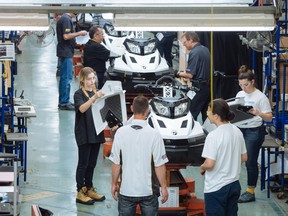 Workers and students at the manufacturing line for the BRP Tundra snowmobile at the company's assembly plant in Valcourt, Que.