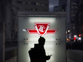 A man uses his cellphone as he walks out of the Toronto Transit Commission entrance at Union Station on Front Street in Toronto.