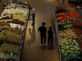 Shoppers select produce at a grocery store in Toronto.