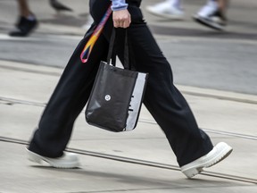 A pedestrian walks with a Lululemon Athletica shopping bag in Toronto.