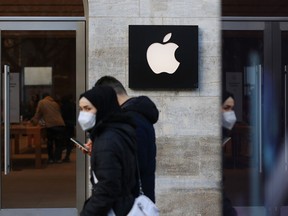 Shoppers pass an Apple Inc. store in Berlin, Germany.