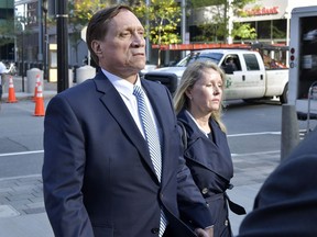 FILE - John Wilson, left, and his wife leave federal court after he was found guilty of participating in a fraudulent college admissions scheme, Oct. 8, 2021, in Boston. The former Staples Inc. executive Wilson, whose fraud and bribery convictions in the sprawling college admissions cheating scandal were thrown out by an appeals court, was sentenced on Friday, Sept. 29, 2023, to six months of home confinement for a tax offense.