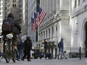 People pass the front of the New York Stock Exchange in New York, Tuesday, March 21, 2023.