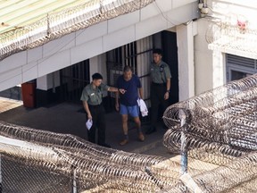 FILE - Jimmy Lai, center, exits his building to go for exercise at the Stanley prison in Hong Kong, Friday, Aug. 4, 2023. The son of jailed Hong Kong media mogul and prominent pro-democracy activist Lai said Wednesday, Sept. 20, he did not want to see his father die in detention, as his lawyers raised the prospect that his long-delayed trial may be pushed back indefinitely.