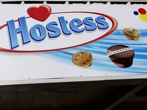 FILE - A Hostess sign is shown on a closed retail outlet store in Garland, Texas, Jan. 11, 2012. Hostess, the maker of snack classics like Twinkies and HoHos, is being sold to J.M. Smucker in a cash-and-stock deal worth about $5.6 billion. Smucker, which makes everything from coffee to peanut butter and jelly, will pay $34.25 per share in cash and stock, and it will also pick up approximately $900 million in net debt.