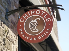 FILE - The Chipotle Mexican Grill logo hangs outside a restaurant location, Dec. 20, 2022. On Wednesday, Sept. 27, 2023, a federal agency sued the restaurant chain Chipotle, accusing it of religious harassment and retaliation after a manager at a Kansas location forcibly removed an employee's hijab, a headscarf worn by some Muslim women.