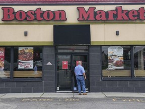 FILE - A man reads a stop work order posted on the door of a Boston Market restaurant in Hackensack, N.J., Thursday, Aug. 17, 2023. State labor officials have lifted a stop-work order, Friday, Sept. 15, 2023, that had temporarily shut down more than two dozen Boston Market restaurants in New Jersey. The move came after officials say the owner paid more than $630,000 in back wages to hundreds of workers.