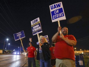 Picketers stand next to a road outside the Stellantis Toledo Assembly Complex early Friday, Sept. 15, 2023, in Toledo, Ohio. Members of the United Auto Workers union began picketing at a General Motors assembly plant in Wentzville, Mo., a Ford factory in Wayne, Mich., near Detroit, and the Stellantis Jeep plant in Toledo.