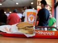 A chicken sandwich sits on a table at a Popeyes as guests wait in line in Texas, in 2019.