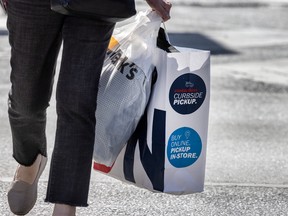 A pedestrian holding shopping bags in Toronto.