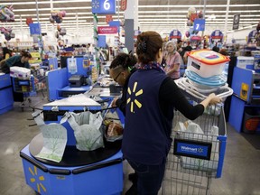 A cashier places items into a customer's shopping cart at a Walmart store in California.