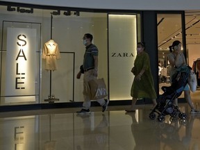 FILE - A man with a shopping bag walks out from a ZARA flagship store at a shopping mall in Beijing, on June 21, 2023. American companies operating in China view tensions with Washington over technology, trade and other issues as a major hindrance for their businesses there, according to a survey by the American Chamber of Commerce in Shanghai.
