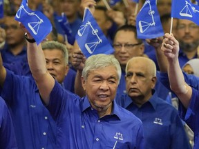 FILE - United Malays National Organization (UMNO) and Barisan National (National Front) coalition President Ahmad Zahid Hamidi, foreground, waves coalition flags during an event naming general election candidates at a hotel in Kuala Lumpur, Malaysia on Nov. 1, 2022. A Malaysian court on Monday, Sept. 4, 2023 dismissed 47 corruption charges against Deputy Prime Minister Ahmad Zahid Hamidi at an advanced stage of his trial.