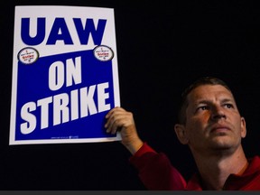Members of the UAW picket and hold signs outside of the UAW Local 900 headquarters across the street from the Ford Assembly Plant in Wayne, Michigan on Sept. 15.