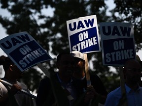 Members of the United Auto Workers (UAW) Local 230 and their supporters walk the picket line in front of the Chrysler Corporate Parts Division in Ontario, Calif., on Sept. 26.