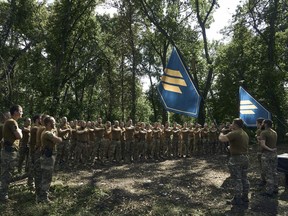 Soldiers of Ukraine's 3rd Separate Assault Brigade shout slogans as they stand in line, near Bakhmut, the site of fierce battles with the Russian forces in the Donetsk region, Ukraine, Sunday, Sept. 3, 2023.