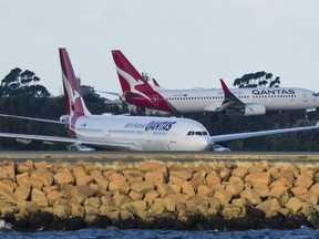 FILE - Qantas passenger jets cross as they taxi at Sydney Airport in Sydney, Australia, on Sept. 5, 2022. Australia's consumer watchdog on Friday, Sept. 1, 2023, called for Qantas Airways to be punished with a record fine for allegedly selling tickets on thousands of flights that had already been canceled.