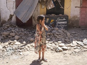 A child reacts after inspecting the damage caused by the earthquake, in her town of Amizmiz, near Marrakech, Morocco, Sunday, Sept. 10, 2023. An aftershock rattled Moroccans on Sunday as they prayed for victims of the nation's strongest earthquake in more than a century and toiled to rescue survivors while soldiers and workers brought water and supplies to desperate mountain villages in ruins.