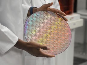 A group of technology organizations is calling on the federal government to bolster Canada's semiconductor industry or risk funding, talent and companies moving elsewhere. Yann Lapnet holds a silicon wafer with chips etched into it at a site where Applied Materials plans to build a $4 billion research facility, in Sunnyvale, Calif., Monday, May 22, 2023.