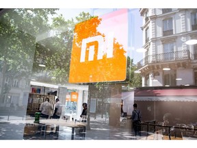A logo sits in the window of a Xiaomi Corp. store in Paris, France, on Friday, May 25, 2018. Chinese smartphone maker Xiaomi opened it's first store in Paris and plans for more shops in France, Spain and Italy, testing the appetite of consumers in developed markets as its executives consider a U.S. expansion. Photographer: Christophe Morin/Bloomberg