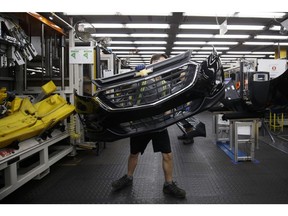An employee carries a General Motors Co. (GM) Chevrolet bumper at the Magna International Inc. Polycon Industries auto parts manufacturing facility in Guelph, Ontario, Canada, on Thursday, Aug. 30, 2018. Canadian stocks and the dollar extended gains Monday on news of a U.S.-Mexican trade agreement, shrugging off U.S. President Donald Trump's threats that Canada might be frozen out and instead face auto tariffs. Photographer: Cole Burston/Bloomberg