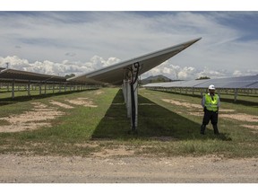 Un agent de sécurité se tient devant des panneaux solaires de la centrale solaire photovoltaïque Enel Green Power Mexico Don Jose à San Luis de la Paz, dans l'État de Guanajuato, au Mexique, le mercredi 14 août 2019. Les réformes énergétiques entamées en 2013 ont ouvert la porte à l'investissement privé et a spécifiquement encouragé l'énergie propre via des enchères d'électricité compétitives, mais les nouveaux projets visant à renforcer le contrôle de l'État sous le président mexicain Lopez Obrador, potentiellement aux dépens du secteur privé, obligent à un changement de cap.