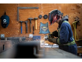 A workers grinds a steel assembly at Macon Industries in Parksville, British Columbia, Canada, on Friday, Feb. 11, 2022. Macon Industries designs, fabricates, and assembles mining technology and mining exploration equipment.