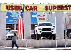 GLENDALE, CALIFORNIA - FEBRUARY 15: A pedestrian walks past a used car lot on February 15, 2023 in Glendale, California. The Commerce Department released data today showing that retail sales saw a three percent jump in January, the biggest gain in almost two years. Sales increased 6.4 percent at automobile and other vehicle dealers.