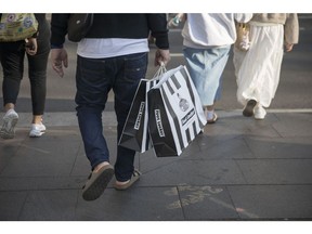 A man carries Foot Locker branded shopping bags in Sydney, Australia, on Sunday, Sept. 3, 2023. Australia is scheduled to release its second-quarter gross domestic product (GDP) figures on Sept. 6. Photographer: Brent Lewin/Bloomberg