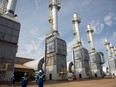 Employees walk by natural gas steam generators at the Cenovus SAGD oilsands facility near Conklin, Alta.