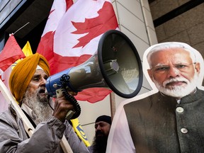 A Sikh protestor yells into a megaphone beside an image of Indian Prime Minister Narendra Modi out front of the Indian Consulate in Toronto, on Sept. 25.