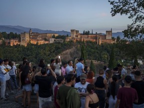 Tourists sit at the Saint Nicholas square backdropped by the Alhambra in Granada, southern Spain, Wednesday, Oct. 4, 2023. Almost all of Europe's leaders will gather Thursday in and around one on of the most renowned havens of tranquility Spain's Alhambra Palace seeking to fix their increasingly turbulent and violent continent which is seeing war and political instability starting to unhinge nations and institutions.
