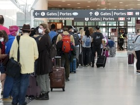 People line up before entering the security at Pearson International Airport in Toronto.