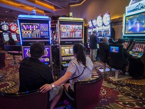 Patrons play slot machines inside the MGM Resorts International Grand Hotel & Casino in Las Vegas, Nevada.