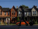 A person walks past a row of houses in Toronto.