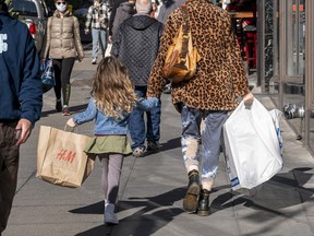 Pedestrians carry shopping bags on Powell Street in San Francisco, California.