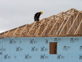 A construction worker works on a house in a new housing development in Oakville, Ont.