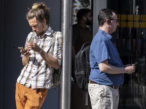 Pedestrians using their phones on Toronto's Dundas Street.
