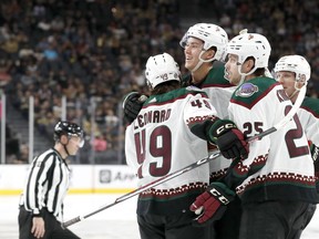 Arizona Coyotes defenseman Maveric Lamoureux, center, celebrates with forward John Leonard (49) and center Justin Kirkland (25) after scoring against the Vegas Golden Knights during the second period of a preseason NHL hockey game Friday, Sept. 29, 2023, in Las Vegas.