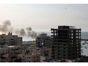 A plume of smoke rises above the port in the Gaza Strip after an Israeli air strike on Oct. 8, 2023. Photographer: Mohammed Abed/AFP/Getty Images