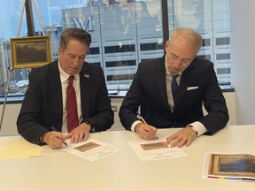 FBI Special Agent David White, left, and Bernd Ebert, a curator at the Alte Pinakothek in Munich, sign documents returning the 18th century painting titled "Landscape of Italian Character" by Vienna-born artist Johann Franz Nepomuk Lauterer, Thursday, Oct. 19, 2023 in Chicago. After going missing nearly 80 years ago, the "Landscape of Italian Character", a baroque landscape painting was returned to a German museum representative in a brief ceremony at the German Consulate in Chicago, where the pastoral piece of an Italian countryside was on display.